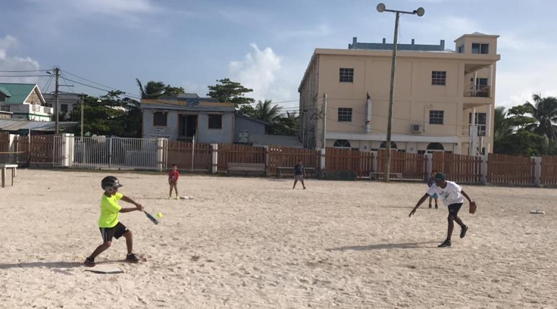 Children play a ball game with volunteer sports coaches in schools in Belize A Projects Abroad volunteer coaching sports in schools in Belize encourages players